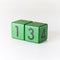 Number thirteen written on a wooden green cube on white background
