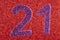 Number twenty-one purple over a red background. Anniversary.