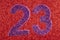 Number twenty-three purple over a red background. Anniversary.