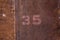 The number written on the rusty metal plating