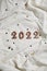 numbers 2022 on grey crumpled textiles. top view new year celebration concept.