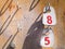 Numbers 8 and 5 on tags hanging in an old wooden