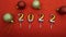 The numbers of the new year 2022 surrounded by Christmas balls