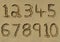 Numbers one to ten written on a sandy beach.