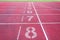 Numbers starting point on red running track,running track and green grass