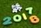 Numeral 2017 2018 on green grass with silver Christmas bow