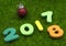 Numeral 2018 on green grass with red Christmas ball