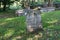 Numerous old weathered headstones and lengths of stonewalls, Walloon Cemetery, historic Huguenot Street, New York, 2018