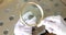 Numismatist in white gloves examining old coin with magnifying glass closeup 4k movie slow motion