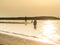 A nun walking long the shoreline of an Italian beach in the earl