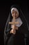 Nuns praying to the GOD while holding a crucifix symbol on black background