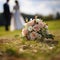 Nuptial scene Wedding bouquet rests on grass with married couple