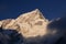 Nuptse mountain at sunset. Summit of Everest on the left side of photo between rocks