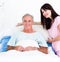 A nurse adjusting pillows for a senior patient