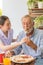 Nurse assist senior man having breakfast together