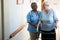 Nurse assisting patient in walking with walker at retirement home