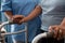 Nurse assisting senior patient in walking with walker at nursing home