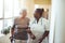Nurse assisting senior woman at nursing homeSenior woman walking in the nursing home supported by a caregiver. Nurse assisting sen
