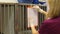 A nurse attaches a clipboard to a cage in a veterinary clinic