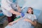 Nurse attaching intravenous tube to patient`s hand in hospital bed