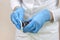 Nurse in blue disposable gloves soaks a cotton swab to disinfect wounds.
