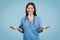 Nurse in blue gesturing, online consulting on blue backdrop