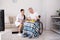 Nurse bringing food to patient in wheelchair.