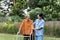 Nurse or caregiver help elderly walk by using walker in garden