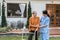 Nurse or caregiver help elderly walk by using walker in garden