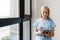 Nurse checking patient records, standing in hospital