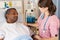 Nurse Checking Senior Patient On Ward