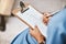 Nurse, clipboard and writing checklist for patient, healthcare consulting and medical information. Closeup doctor hands