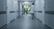 Nurse comes to elderly woman in clinic corridor