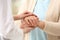 Nurse comforting elderly woman against blurred background. Assisting senior generation