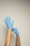 Nurse or cosmetologist putting on medical latex glove isolated. Copy space