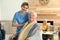 Nurse covering elderly man with blanket at retirement home