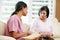 Nurse Discussing Records With Senior Female Patient During Home