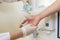 Nurse disinfects a patients hand at a sink
