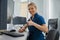 Nurse on Duty working on computer at the Reception Desk in modern clinic and showing thumb up