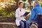 Nurse with elderly man disabled in wheelchair