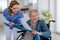 Nurse exercising with senior woman at her home, concept of healthcare and rehabilitation.