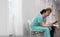 Nurse explaining medical form to young patient while sitting in corridor at hospital