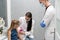 A nurse is getting ready to inject a little girl with a previously prepared vaccine. The young apprentice tries to talk