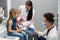 A nurse is getting ready to inject a little girl with a previously prepared vaccine. The young apprentice tries to talk