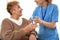 Nurse giving glass of water to elderly woman. Medical assistance