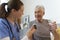 Nurse giving pills senior man in his home.