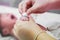 Nurse hands using cotton wool swab with alcohol to clean the sick newborn baby`s hand