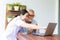 Nurse help senior retirement man working with laptop at home