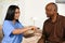 Nurse Helping An Elderly Man Take Pills