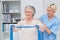 Nurse helping senior patient in exercising with resistance band